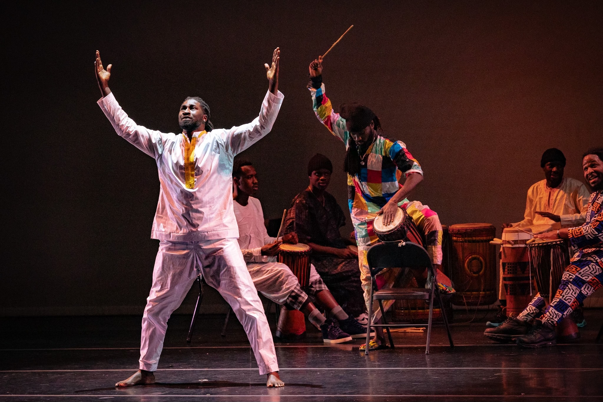 Bakary Fall performing with live drummers on stage