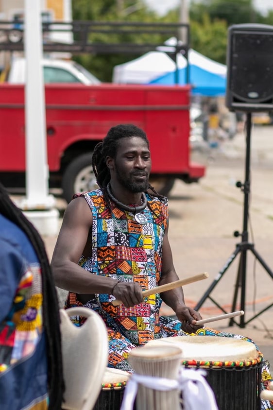 Bakary Fall playing djembe at a community event