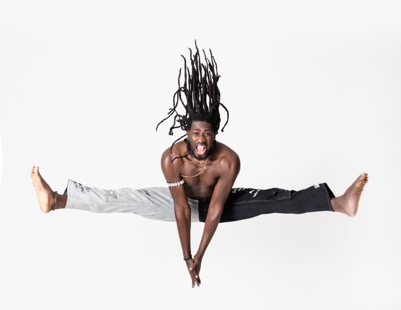 Bakary Fall in a dynamic leap on stage