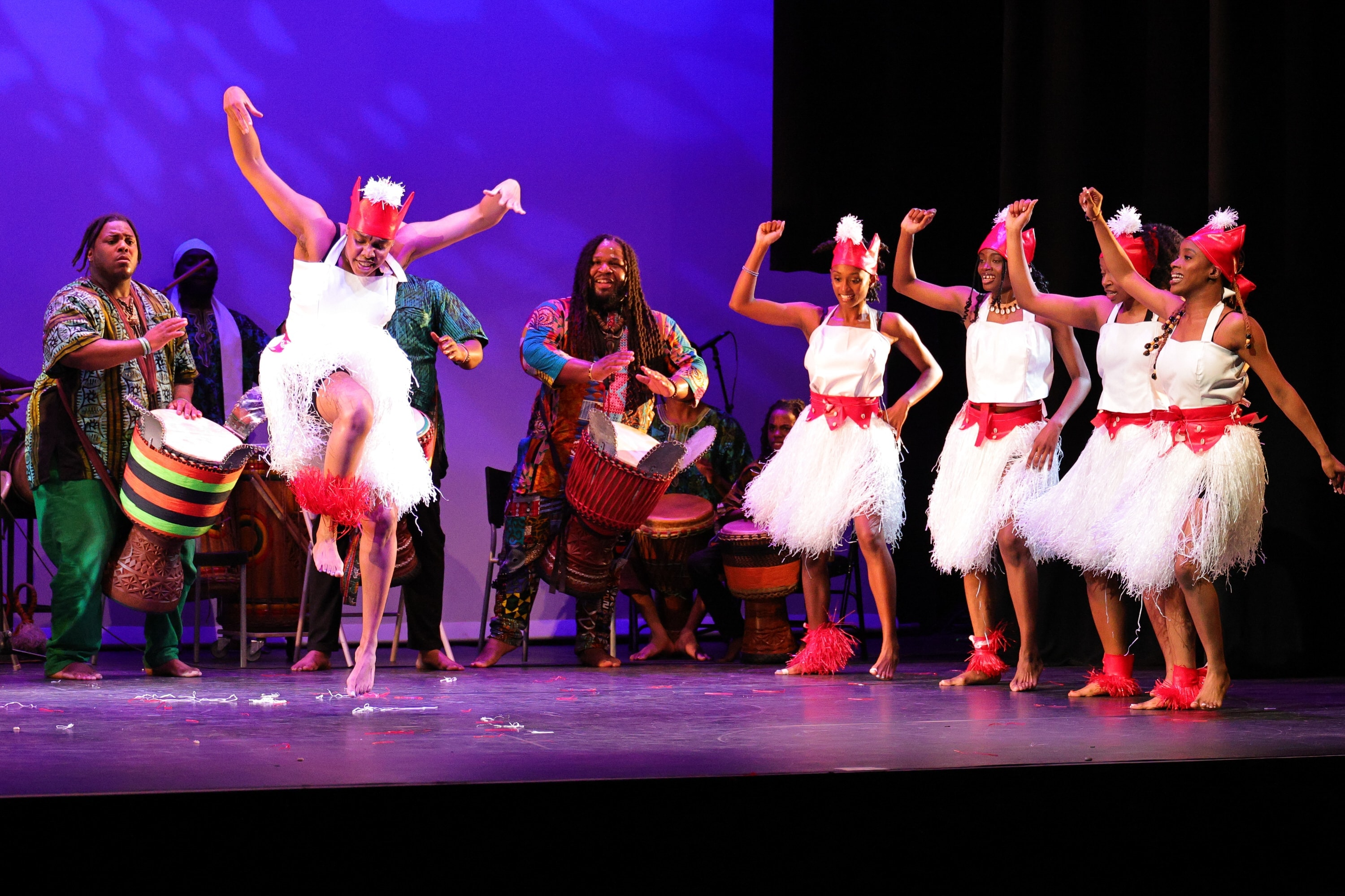 Kofago Dance Ensemble performers on stage with drummers